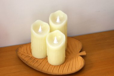 A burning wax candle stands on the table. clipart
