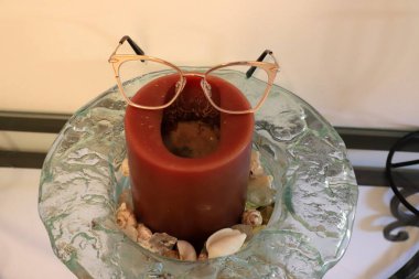 Masanın üzerinde yanan bir mum duruyor..