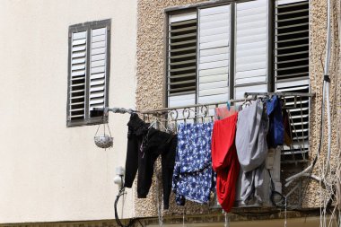 Yıkanmış çamaşırlar pencerenin dışında bir ipe asılı..