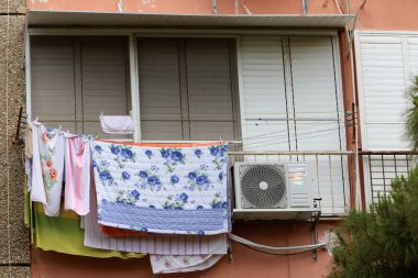 Yıkanmış çamaşırlar pencerenin dışında bir ipe asılı..