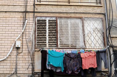 Yıkanmış çamaşırlar pencerenin dışında bir ipe asılı..