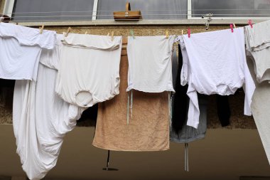 Yıkanmış çamaşırlar pencerenin dışında bir ipe asılı..