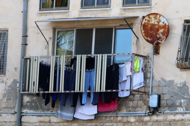 Yıkanmış çamaşırlar pencerenin dışında bir ipe asılı..