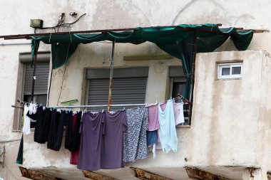 Yıkanmış çamaşırlar pencerenin dışında bir ipe asılı..