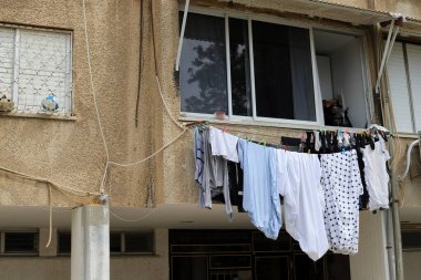 Yıkanmış çamaşırlar pencerenin dışında bir ipe asılı..