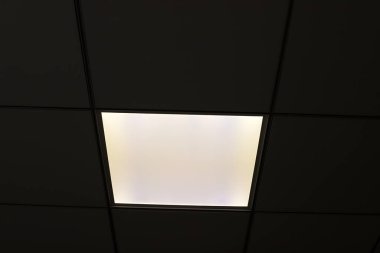 Odanın içini aydınlatan bir lamba tavanda asılı duruyor..