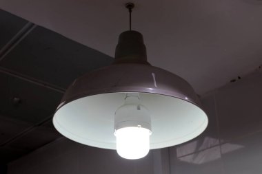 Odanın içini aydınlatan bir lamba tavanda asılı duruyor..