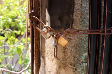 Çitte eski metal bir kilit asılı..