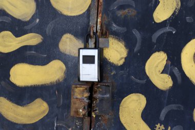 Çitte eski metal bir kilit asılı..