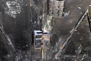 Çitte eski metal bir kilit asılı..