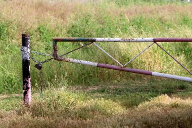 Çitte eski metal bir kilit asılı..
