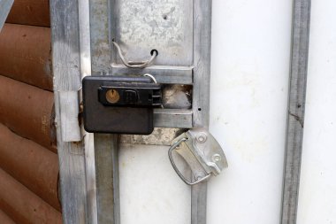 Çitte eski metal bir kilit asılı..