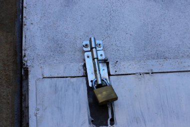 Çitte eski metal bir kilit asılı..