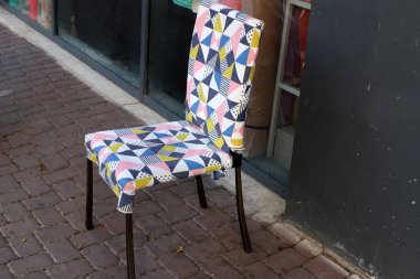 Büyük bir şehirde kaldırımda bir şezlong duruyor..