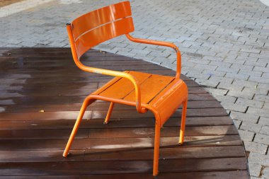 Büyük bir şehirde kaldırımda bir şezlong duruyor..