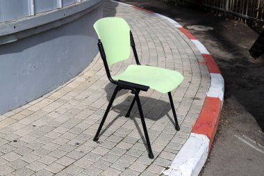 Büyük bir şehirde kaldırımda bir şezlong duruyor..