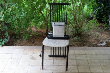 Büyük bir şehirde kaldırımda bir şezlong duruyor..