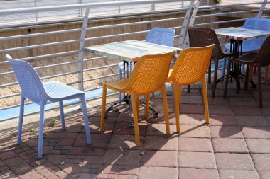 Sahildeki bir kafede sandalye ve masa.