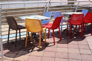 Sahildeki bir kafede sandalye ve masa.