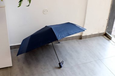 Yağmurdan ve sıcak güneş ışınlarından korunmak için bir şemsiye..