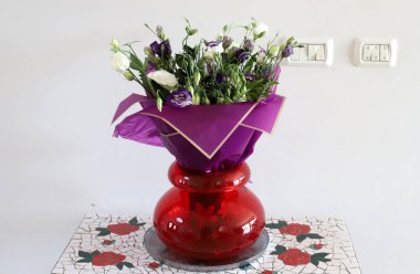 Bir buket çiçek cam vazoda duruyor..