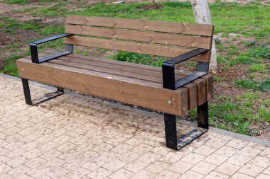 Deniz kıyısındaki bir şehir parkında rahatlamak için bir bank.