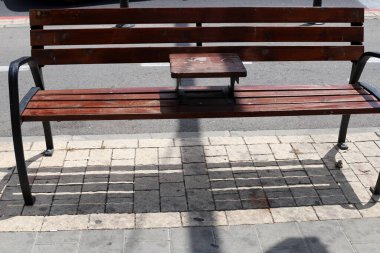 Deniz kıyısındaki bir şehir parkında rahatlamak için bir bank.