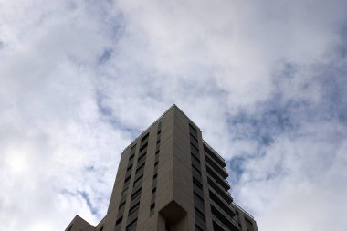 Büyük bir şehirde yüksek binaların üzerinde bulutlar.