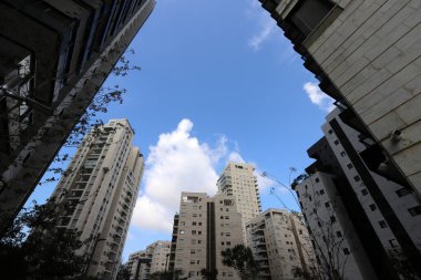 Büyük bir şehirde yüksek binaların üzerinde bulutlar.