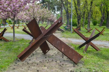 Kyiv, Kyiv bölgesi Ukrayna 05.04.2023: Kentin savunma hattı kiraz ağaçları, tanksavar deniz kestaneleri ve piyadeler için kazılan siperlerle dolu bir parktan geçiyor.