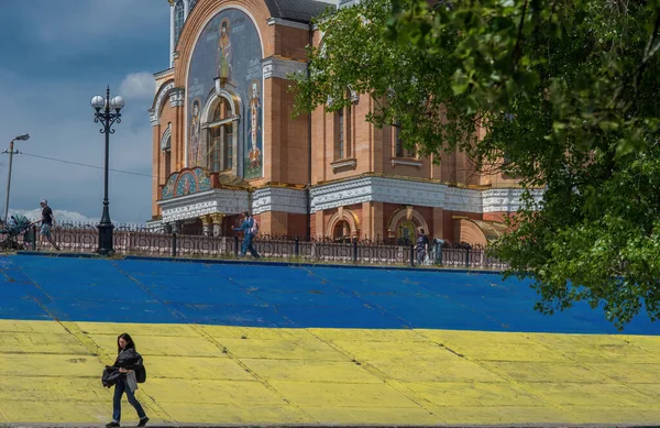 キエフ キエフ地域ウクライナ05 2023 女の子 サイクリスト 高齢者が公園を歩いている 背景には ウクライナの旗の黄色と青の色で描かれたコンクリートスラブがあります — ストック写真