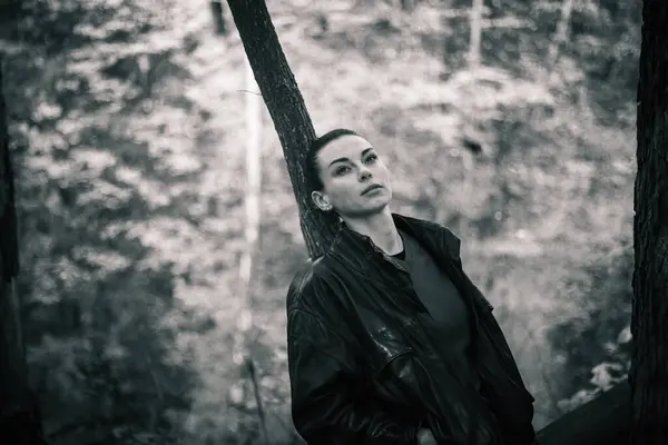 Bahar ormanında poz veren lastik çizmeli bir kız, çiçek açan ağaçlar ve canlı yeşilliklerle çevrili, doğanın yenilenmesinin özünü yayıyor..