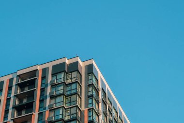 Gökyüzüne karşı modern binaların parçaları, parlak çizgiler, cam yansımalar ve kalın mimari detaylar yakalıyor, kentsel tasarımı ufkun açık genişliğiyle harmanlıyor..