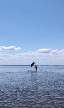 Siyah bayraklı adam denize koşuyor..