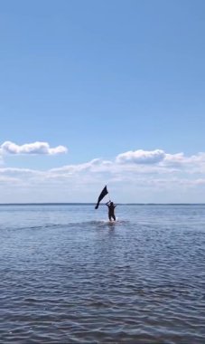 Siyah bayraklı adam denize koşuyor..