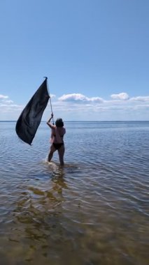 Siyah bayraklı adam denize koşuyor..