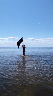 Siyah bayraklı adam denize koşuyor..