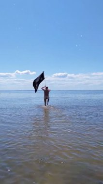 Siyah bayraklı adam denize koşuyor..