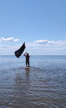 Siyah bayraklı adam denize koşuyor..