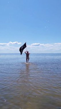 Siyah bayraklı adam denize koşuyor..