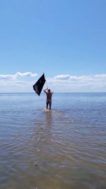 Siyah bayraklı adam denize koşuyor..