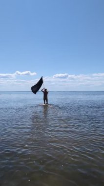 Siyah bayraklı adam denize koşuyor..