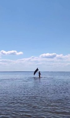 Siyah bayraklı adam denize koşuyor..