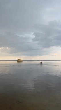 Adam sığ sularda terk edilmiş bir sığınağa doğru yürüyor..