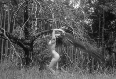 Peçeli kadın bir ağacın yanında duruyor..