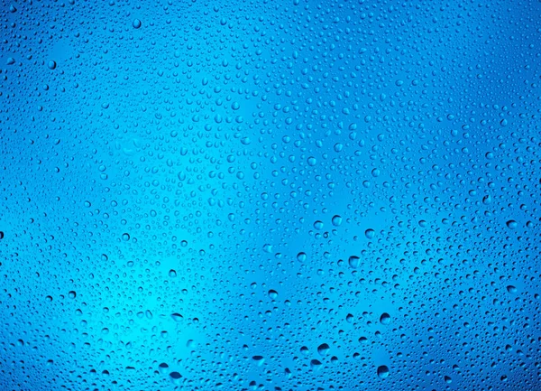 青い背景と水の滴のコントラスト — ストック写真