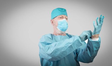 Koruyucu tulumlu ve maskeli bulaşıcı hastalıklar doktoru koruyucu eldiven takıyor..