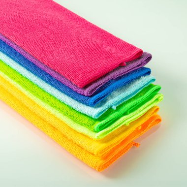 Ayna arka planında parlak renklerde mutfak mikrofiber havluları yığını.