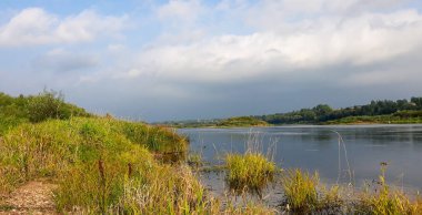 Nehir manzarası. Yazın Letonya 'daki Daugava nehrinin üzerinde fırtınalı bir gökyüzü.