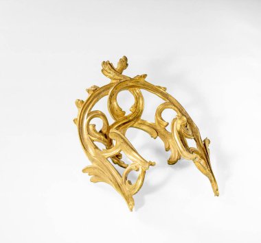 Daugavpils, Letonya, 20 Haziran 2023 Mobilya Teçhizatları. Süslü bronz bir süs, masa bacağı için bir kaplama, beyaz bir arkaplan. Retro tarzı..